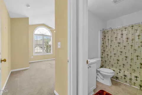 a bathroom with a toilet and a shower curtain