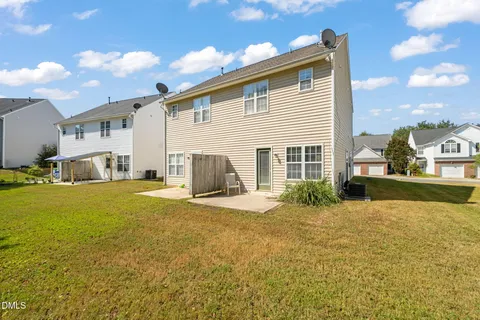 a view of a house with backyard and sitting area