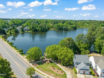 an aerial view of a residential houses with outdoor space and a lake view