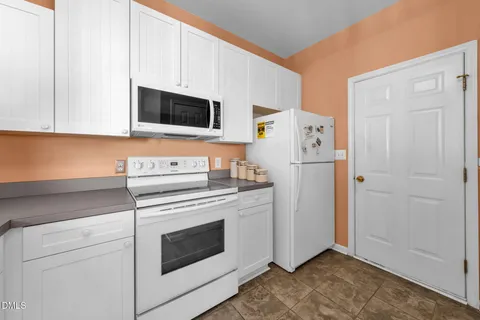 a kitchen with stainless steel appliances white cabinets and a refrigerator