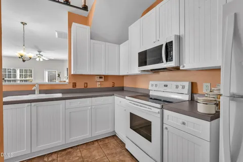 a kitchen with stainless steel appliances granite countertop white cabinets a sink and dishwasher