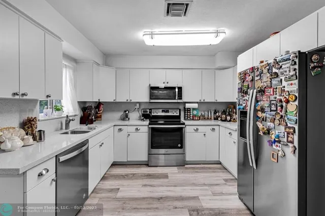 a kitchen with stainless steel appliances granite countertop a refrigerator stove and sink