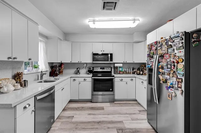 a kitchen with stainless steel appliances granite countertop a refrigerator stove and sink