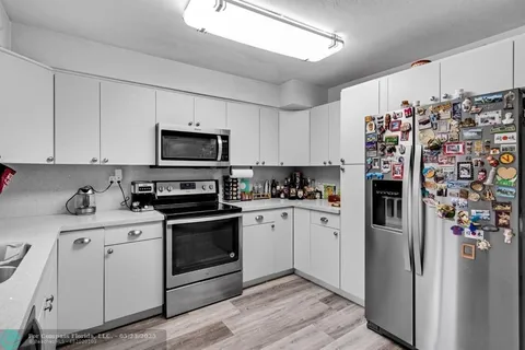 a kitchen with stainless steel appliances granite countertop a refrigerator stove and sink