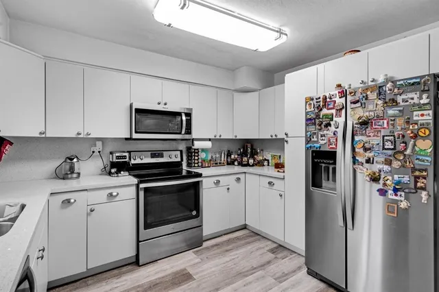 a kitchen with stainless steel appliances granite countertop a refrigerator stove and sink