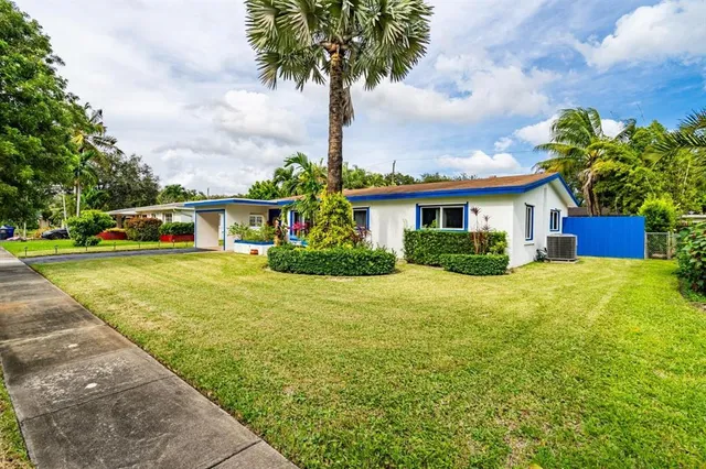 a front view of a house with a yard and trees