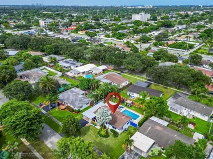 an aerial view of residential houses with outdoor space and trees