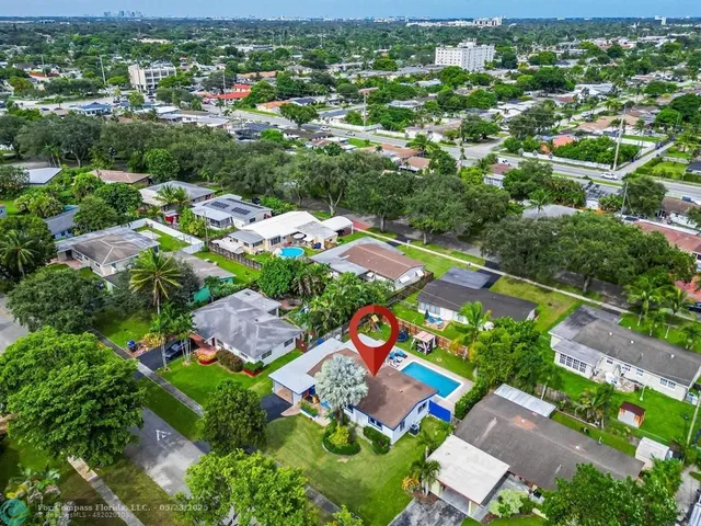 an aerial view of residential houses with outdoor space and trees
