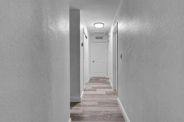 a view of a hallway with wooden floor