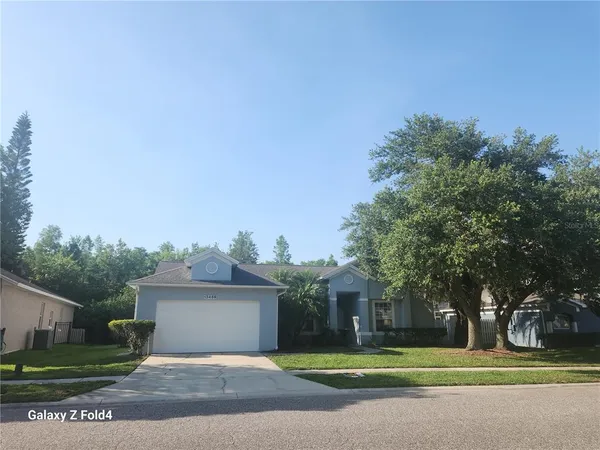 a view of a big house in a big yard with large trees