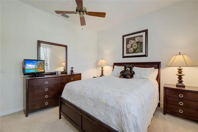 a bedroom with a bed and a lamp on dresser