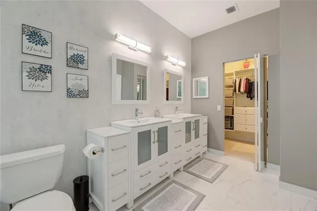 a bathroom with a double vanity sink mirror and toilet