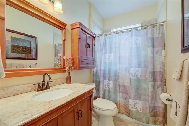 a bathroom with a granite countertop sink toilet and shower