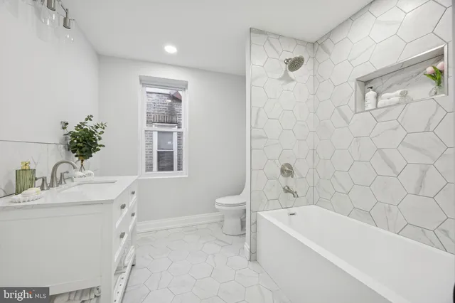 a bathroom with a granite countertop sink a toilet and bathtub