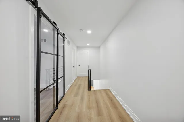 a view of a hallway with wooden floor and staircase
