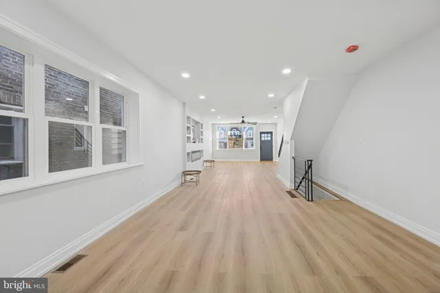 a view of empty room with a window and wooden floor