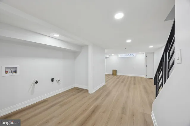 an empty room with wooden floor and entryway