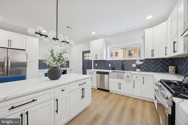 a kitchen with white cabinets and stainless steel appliances