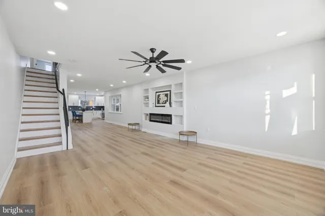 a view of an empty room with a window and a ceiling fan