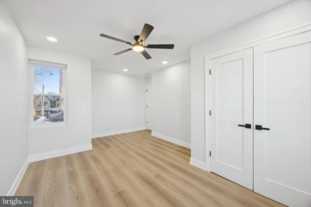 a view of an empty room and window with a chandelier fan