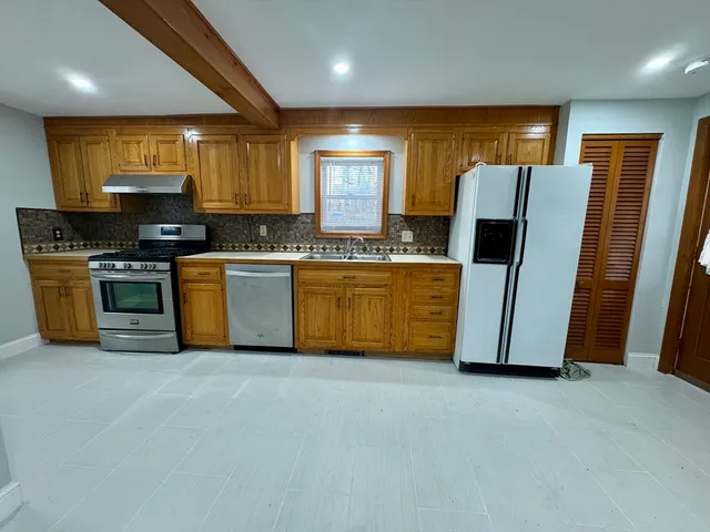 a kitchen with stainless steel appliances granite countertop a stove a sink and a refrigerator