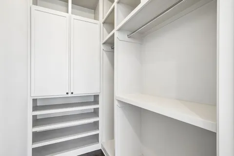 a view of walk in closet with empty racks