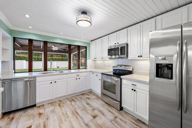 a large kitchen with stainless steel appliances granite countertop a stove and a sink
