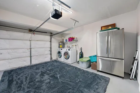 a utility room with refrigerator and microwave