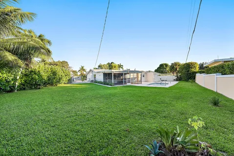 a view of a house with a big yard and potted plants