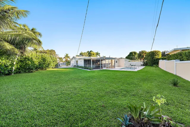 a view of a house with a big yard and potted plants