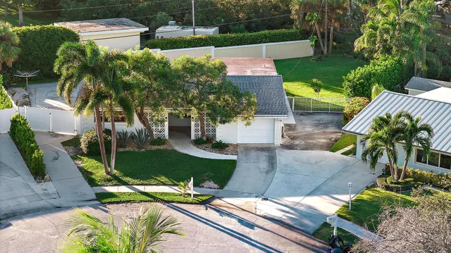 a view of a backyard with table and chairs plants and a fire pit