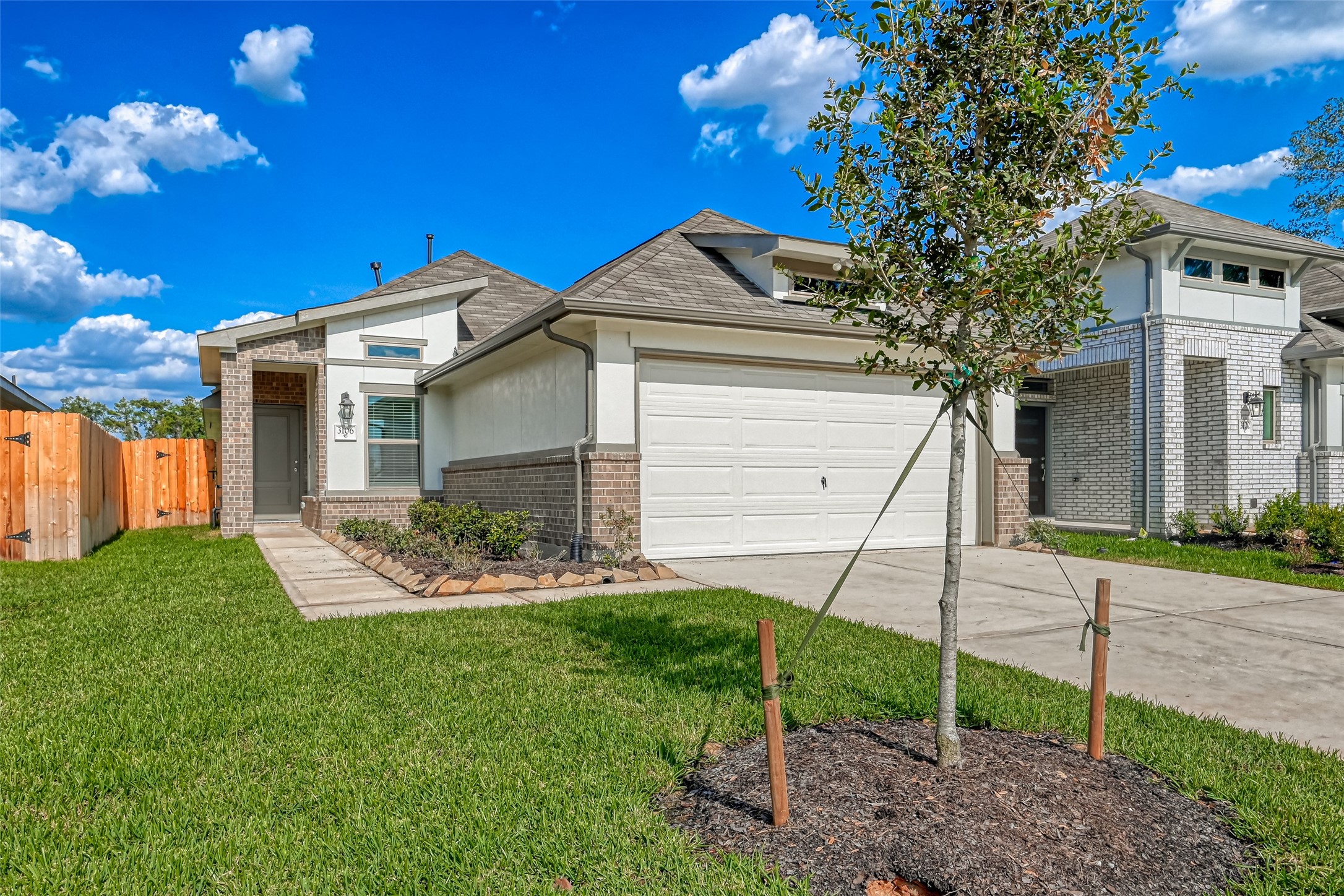 3106 Rising Fir Lane Conroe, TX 77385 - Photo 2 of 32 a front view of a house with a garden and plants