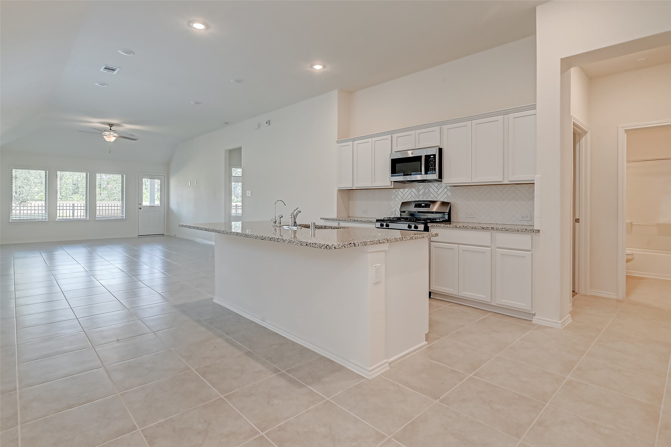 3106 Rising Fir Lane Conroe, TX 77385 - Photo 4 of 32 a kitchen with stainless steel appliances a sink stove and cabinets