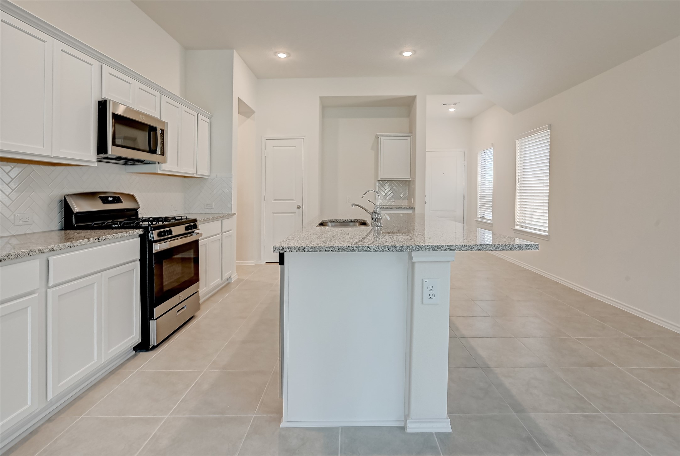 3106 Rising Fir Lane Conroe, TX 77385 - Photo 7 of 32 a kitchen with granite countertop white cabinets and stainless steel appliances