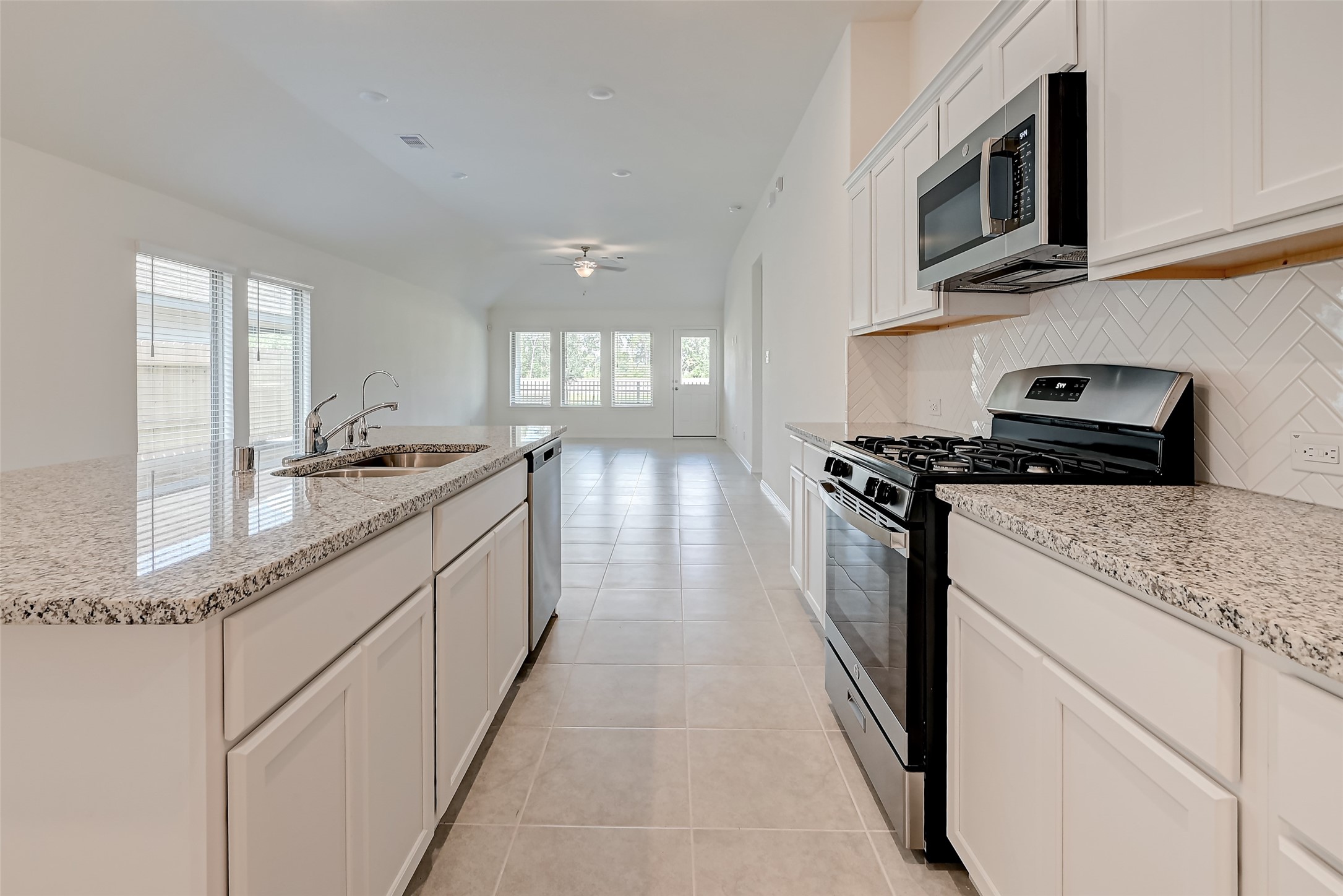 3106 Rising Fir Lane Conroe, TX 77385 - Photo 8 of 32 a kitchen with stainless steel appliances granite countertop a stove and a sink