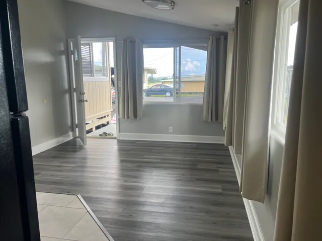 a view of an empty room with wooden floor