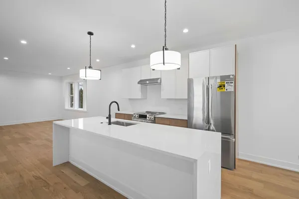 a kitchen with stainless steel appliances a refrigerator sink and wooden floor