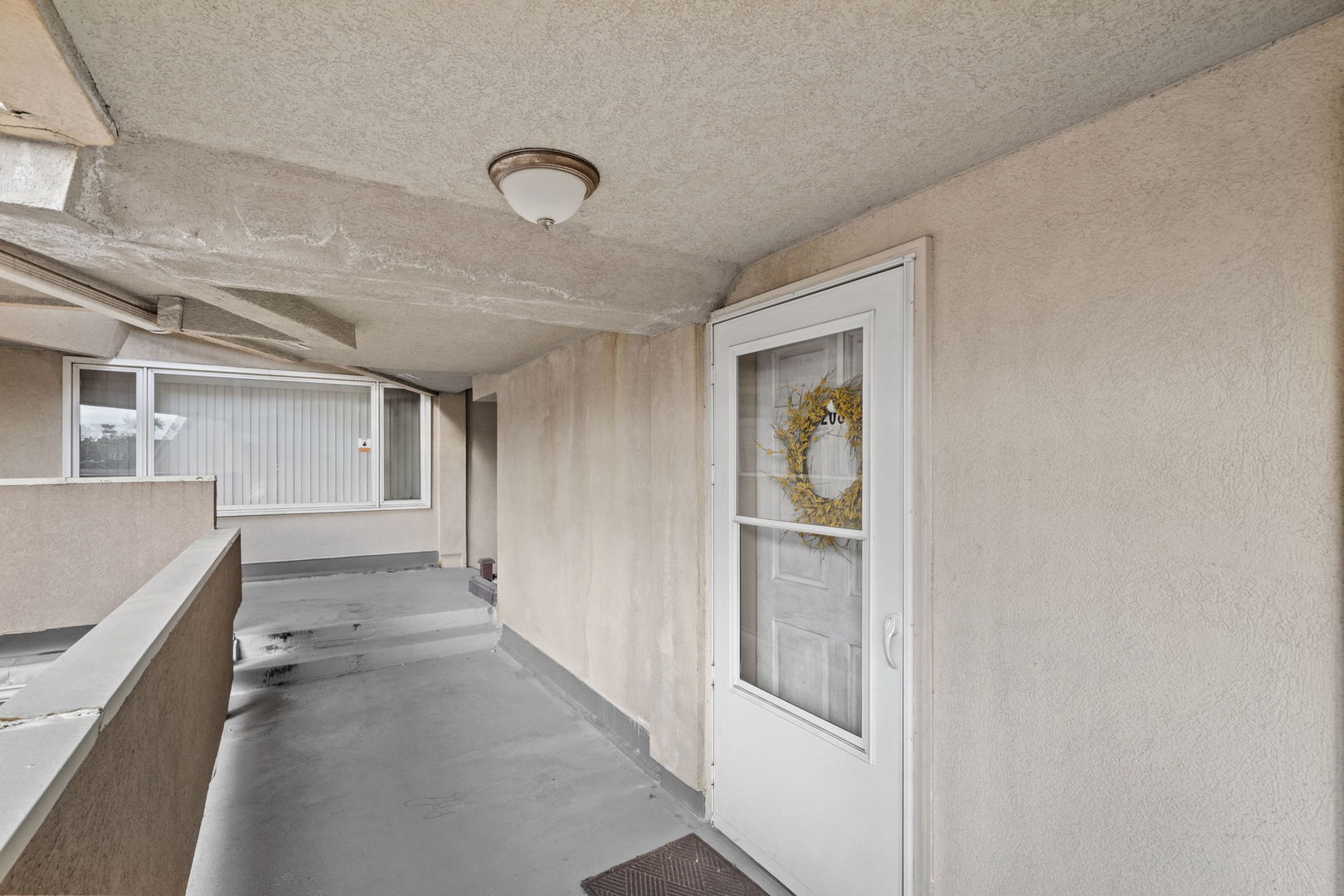 6337 Roosevelt Road, Unit 208 Berwyn, IL 60402 - Photo 10 of 14 a view of a hallway to an empty room with wooden floor and windows