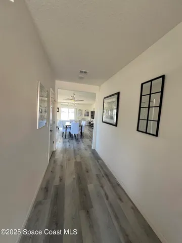 a view of a hallway to a livingroom with furniture