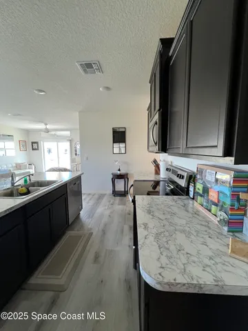 a kitchen with stainless steel appliances granite countertop a sink stove and wooden cabinets