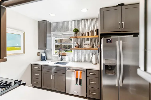 a kitchen with stainless steel appliances a refrigerator and a sink