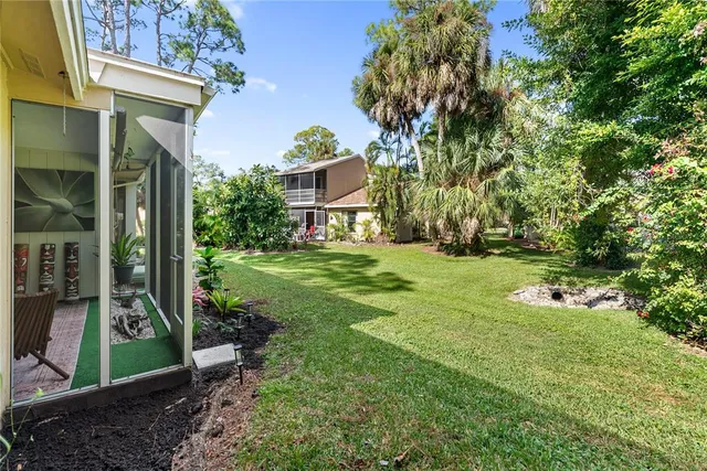 a tennis court that has trees in front of it