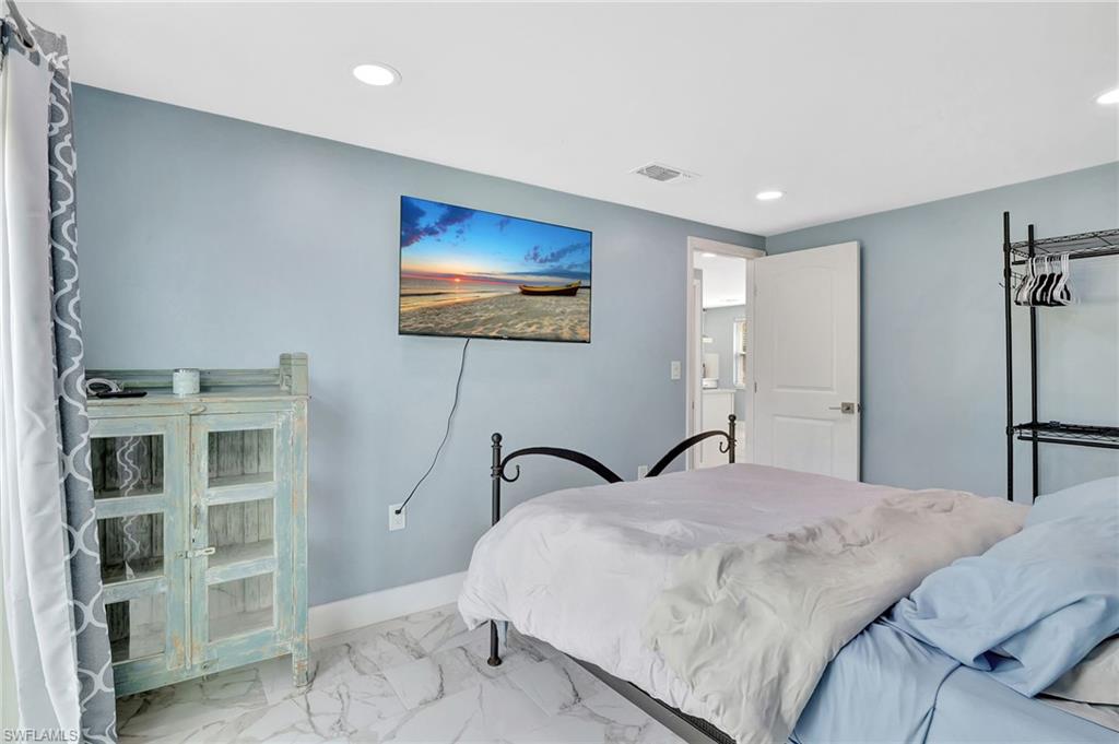1009 Ridge Street Naples, FL 34103 - Photo 18 of 30 a bedroom with a bed and a flat screen tv