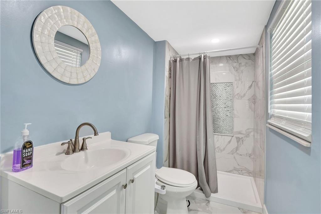 1009 Ridge Street Naples, FL 34103 - Photo 19 of 30 a bathroom with a sink a toilet and a mirror