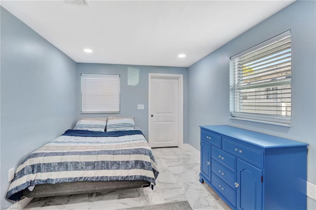 1009 Ridge Street Naples, FL 34103 - Photo 21 of 30 a spacious bedroom with a bed and a window