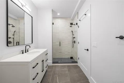 a bathroom with a double vanity sink mirror double and shower