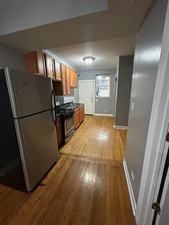 a view of a refrigerator in kitchen and wooden floor
