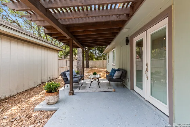 a view of a porch with chairs and potted plants