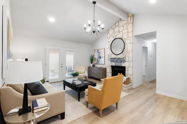 a living room with furniture a fireplace and a chandelier