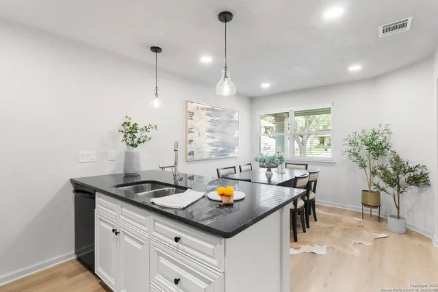 a kitchen that has a lot of cabinets a sink and a stove